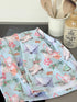 Blue Loft Christmas cotton tea towel with ice skate and candy pattern photographed on a white surface.
