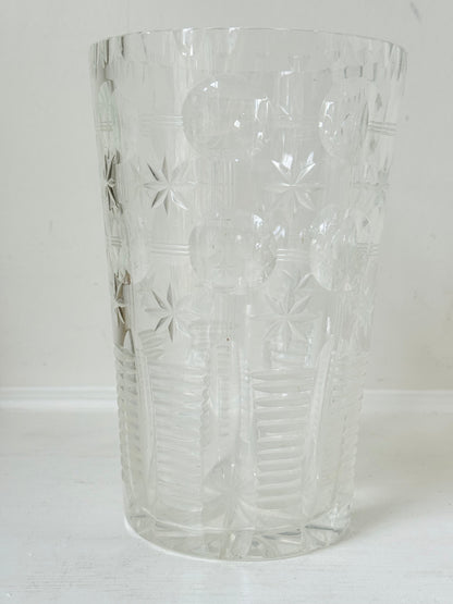Vintage Stuart crystal cut glass vase with floral and star design, photographed on a white surface.