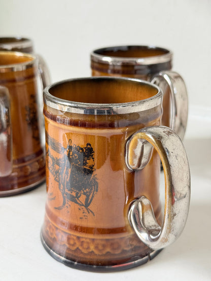 Set of 4 Ridgways stoneware tankard mugs photographed on a white surface in amber brown glaze with black Coaching Days and Coaching Ways transfer scenes