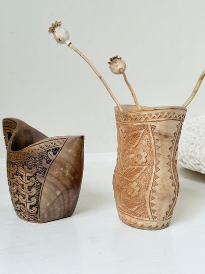 Pair of hand carved wooden jug and vase in contrasting light and dark tones, styled with dried poppy heads on a white surface.