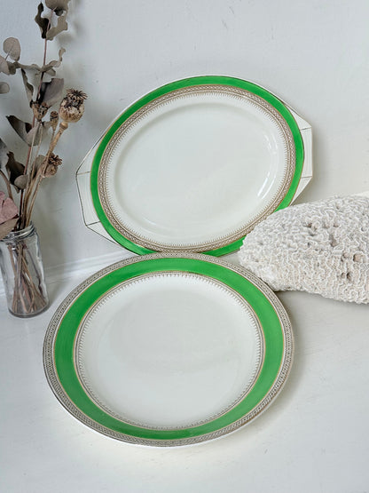 Pair of vintage oval serving platters with bright green Art Deco style border photographed on a white surface