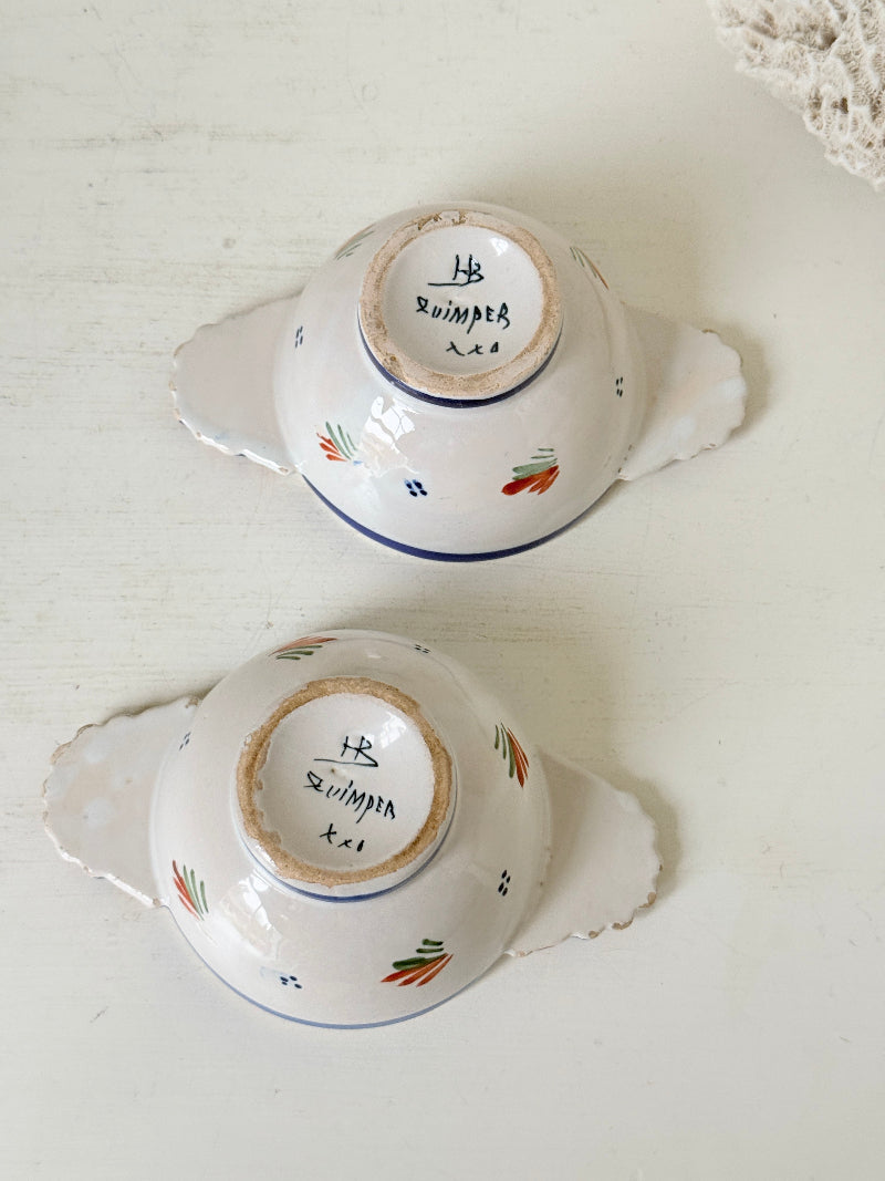 Pair of vintage French Quimper olive bowls with Breton figure and fan handles, photographed on a white surface