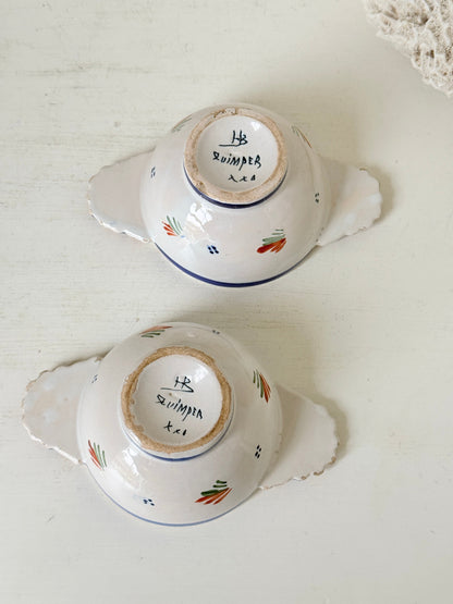 Pair of vintage French Quimper olive bowls with Breton figure and fan handles, photographed on a white surface