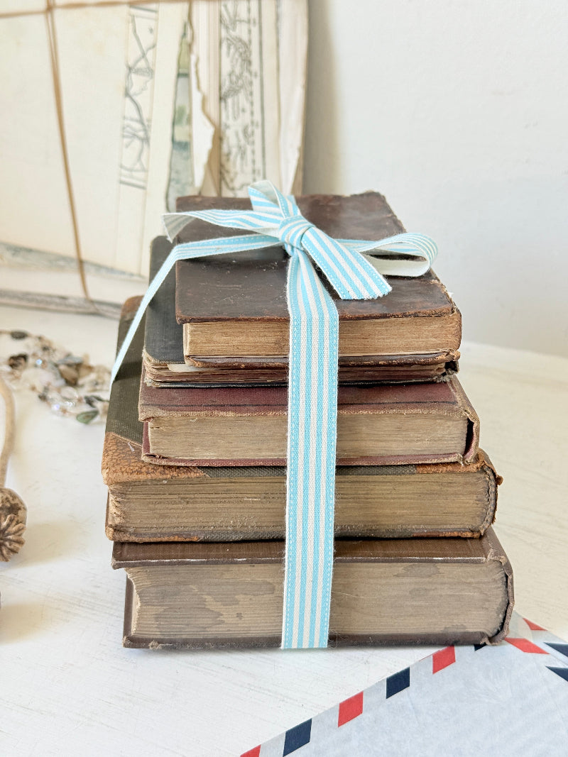 Vintage decorative brown book bundle with aged hardback covers tied with blue stripe ribbon for bookshelf and table styling