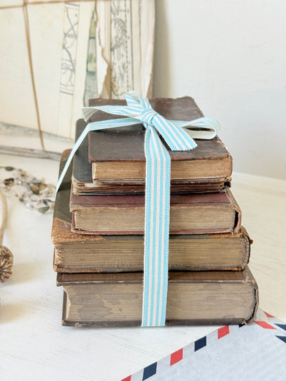 Vintage decorative brown book bundle with aged hardback covers tied with blue stripe ribbon for bookshelf and table styling