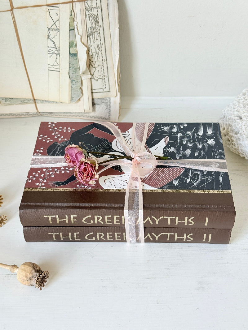 Pair of vintage Greek myths books with brown illustrated covers, pale pink ribbon and dried flower detail for shelf styling