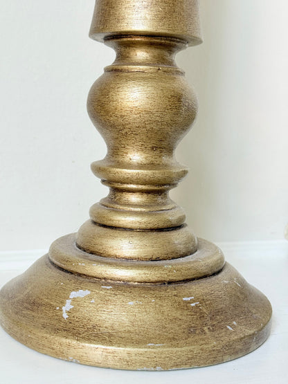Pair of vintage wooden candlesticks, one tall and one small, in golden-toned finish, styled with pillar candles on a white surface.