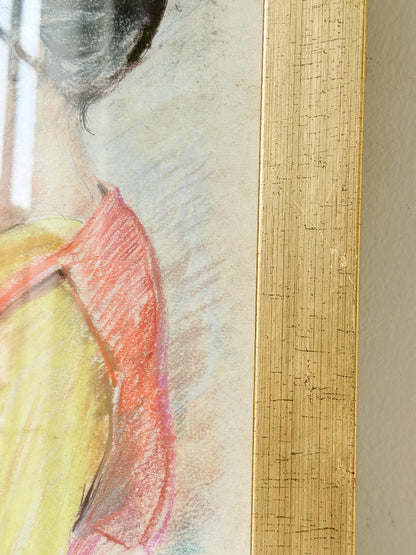 Vintage pastel portrait of a woman in profile wearing red and yellow, framed under glass, photographed on a white surface