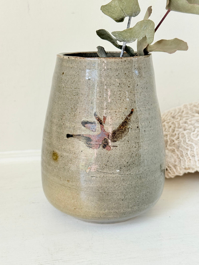 Hand thrown studio pottery vase with ash glaze and brushstroke motif, photographed on white surface