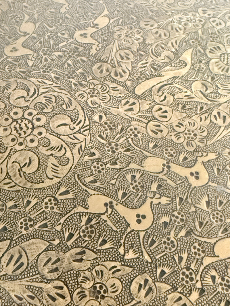 Vintage hand engraved brass wall plaque with floral scrollwork, figural decoration, shaped edge and aged patina
