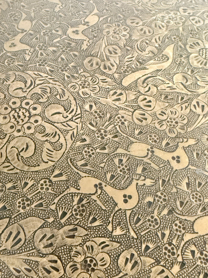 Vintage hand engraved brass wall plaque with floral scrollwork, figural decoration, shaped edge and aged patina