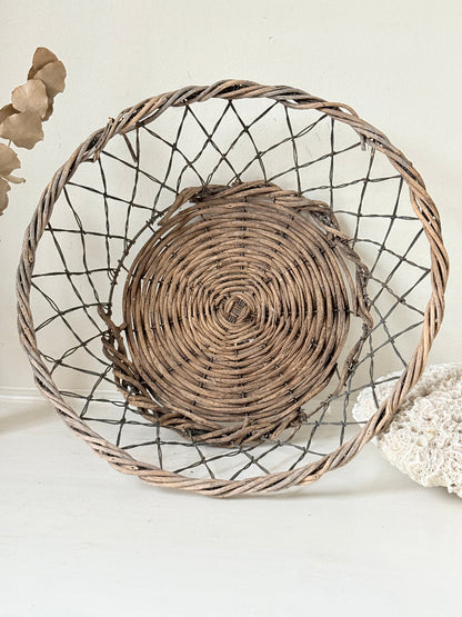 Vintage wicker and wire basket with woven base photographed on a white surface