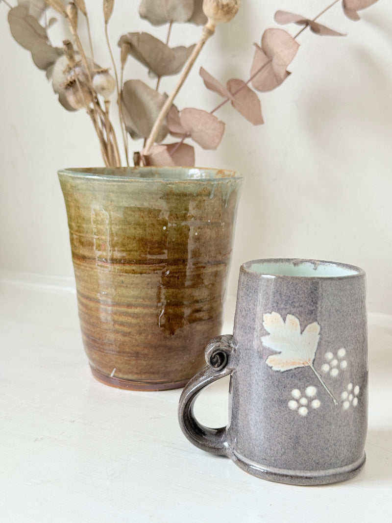 Pair of studio pottery mugs with complementary glazes photographed on a white surface