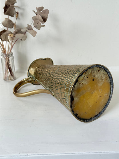 Vintage brass jug with alligator patterned surface, photographed against a white background.