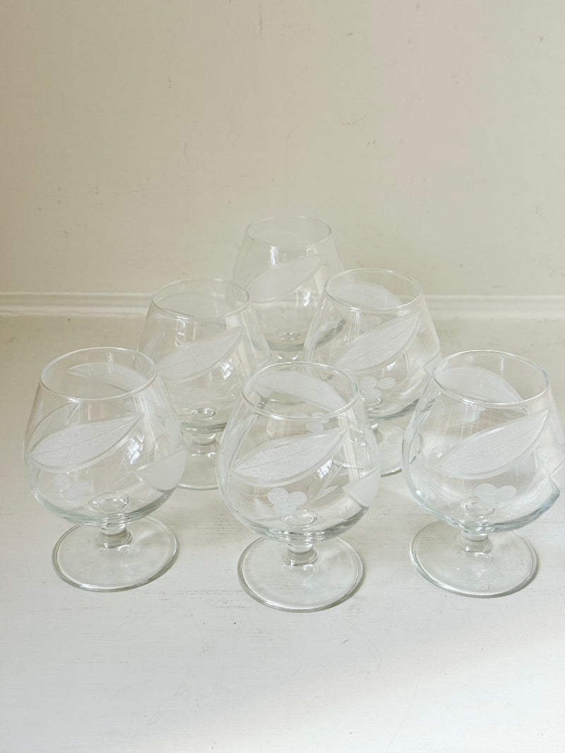 Set of six vintage etched Bailey’s glasses with rounded bowls and short stems, photographed on white surface.