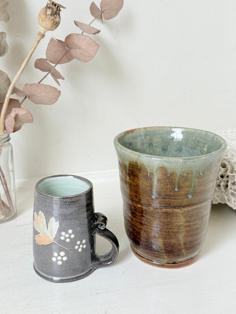 Pair of studio pottery mugs with complementary glazes photographed on a white surface
