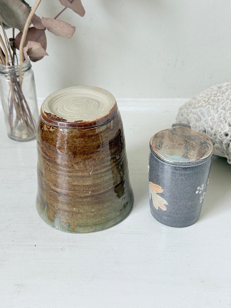Pair of studio pottery mugs with complementary glazes photographed on a white surface