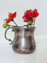 vintage silver plate beaker by arthur price with ornate handle and patina, photographed with red flowers on a white surface