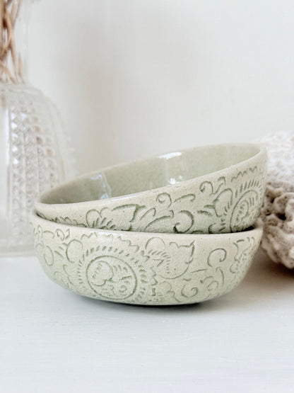 Pair of sage green Thai celadon olive bowls with crackled glaze, photographed on white surface