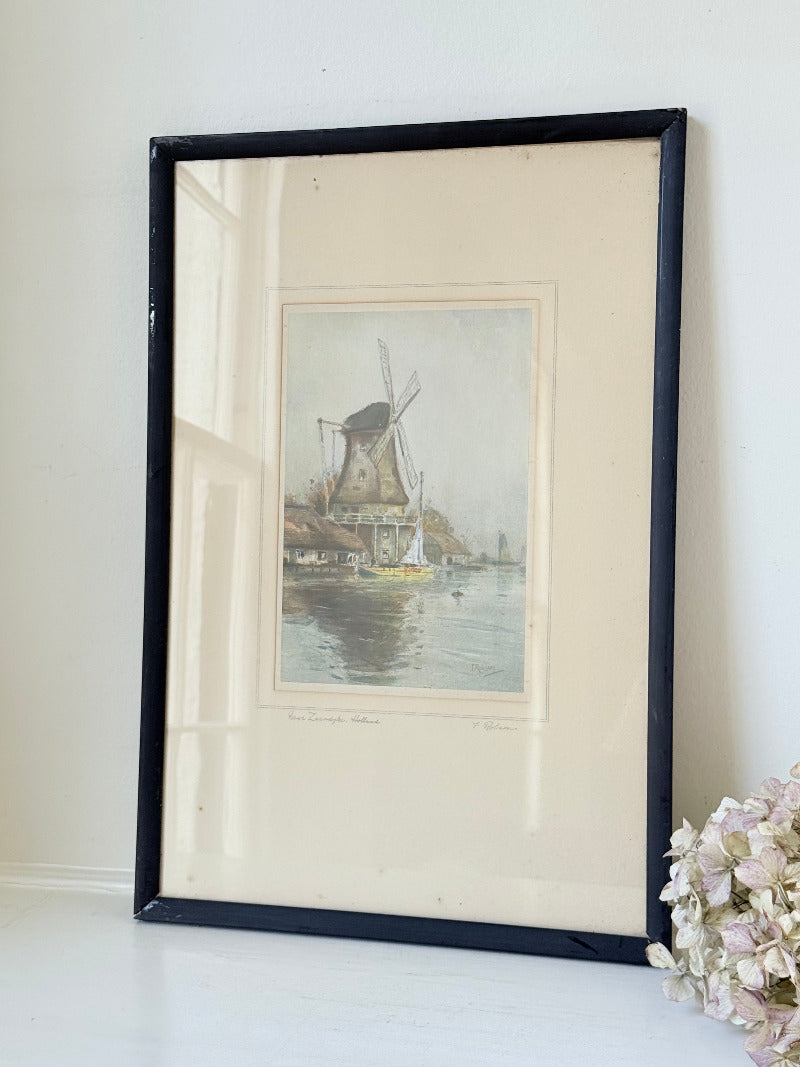 framed print of dutch windmill beside water in holland with reflection photographed on white surface