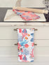 The Blue Loft coral reef cotton tea towels in coral pink and white with coastal inspired pattern photographed on a stone surface.