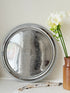 Vintage silver tone round tray with beaded edge, engraved surface detail and reflective finish for drinks or vanity styling