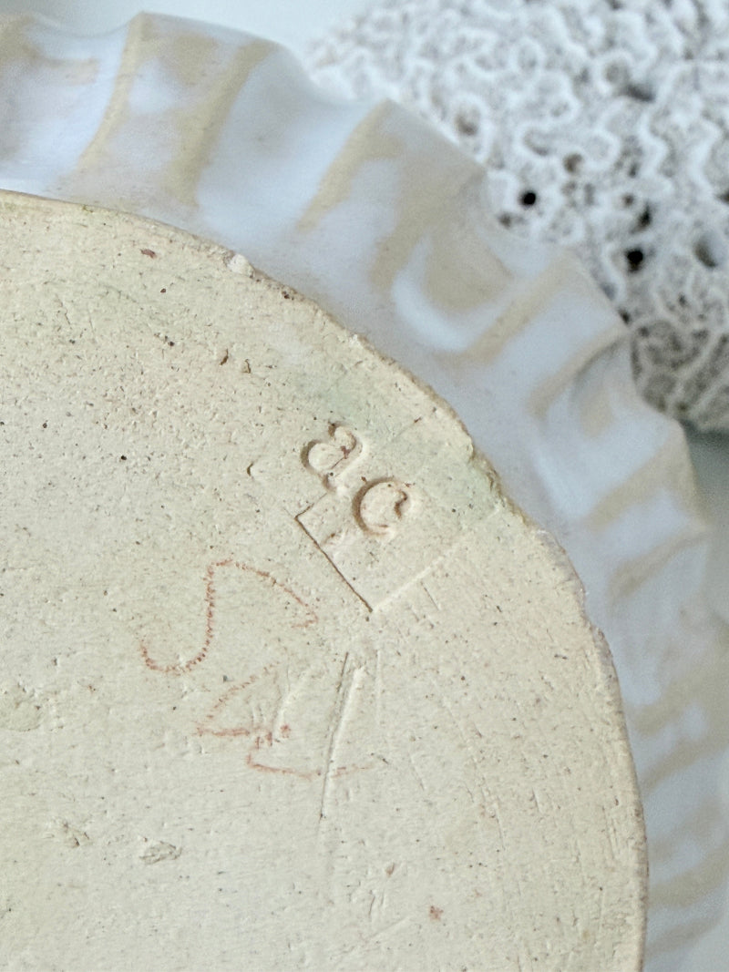 Vintage studio pottery bowl planter in cream and sky blue glaze photographed on a white surface