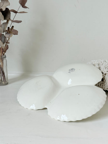 Poole Pottery double scallop hors d’oeuvre dish in white glaze with red handle photographed on a white surface