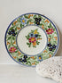 Vintage Italian majolica floral plate with blue green yellow and pink decoration photographed on a white surface