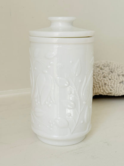 French opale glass jar with floral raised design, white vintage milk glass, shown on white background