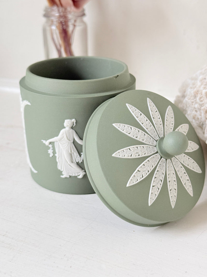 Vintage Wedgwood Jasperware sage green lidded jar with ball finial, decorated with white Dancing Hours neoclassical figures, styled with dried stems.