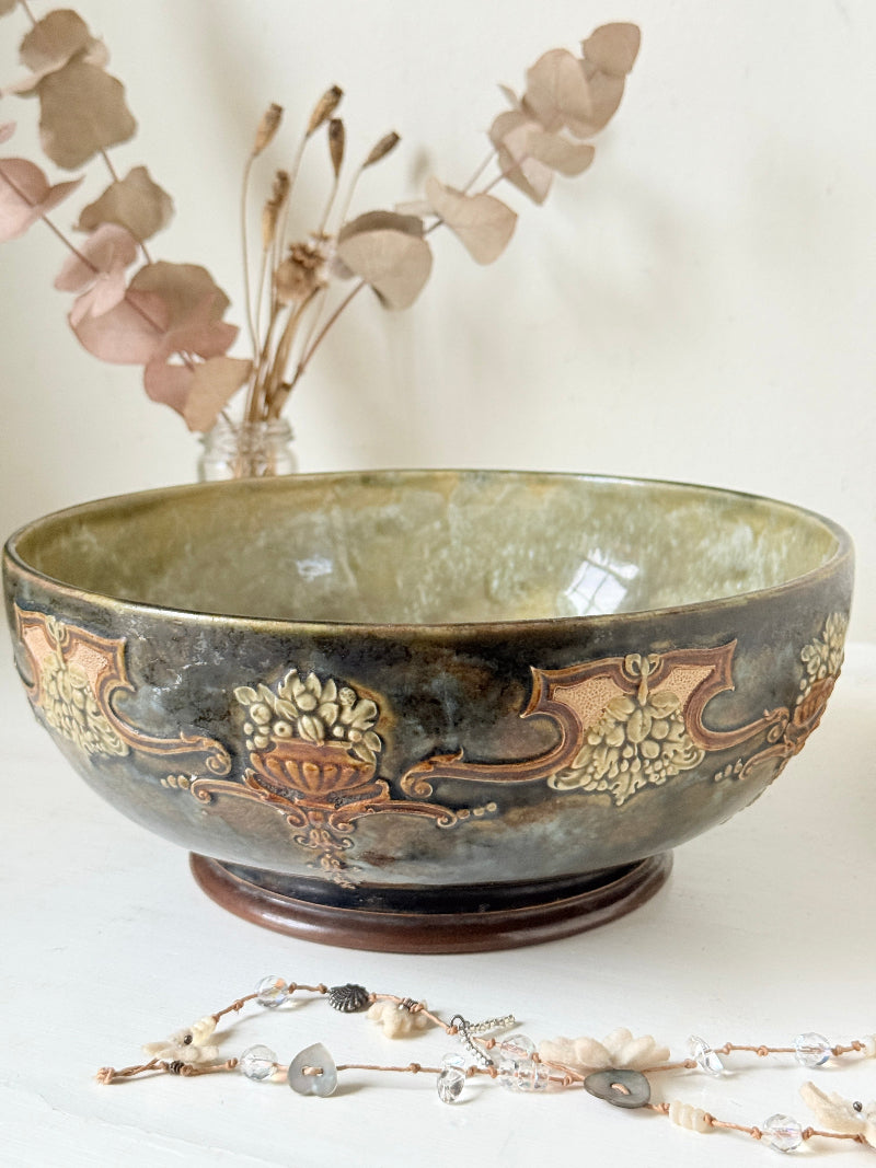 Antique Royal Doulton stoneware fruit bowl with relief floral decoration, photographed on a white surface