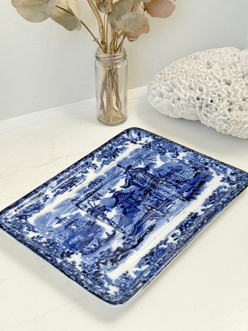 Vintage Wedgwood blue and white rectangular transferware plate with scenic design photographed on a white surface
