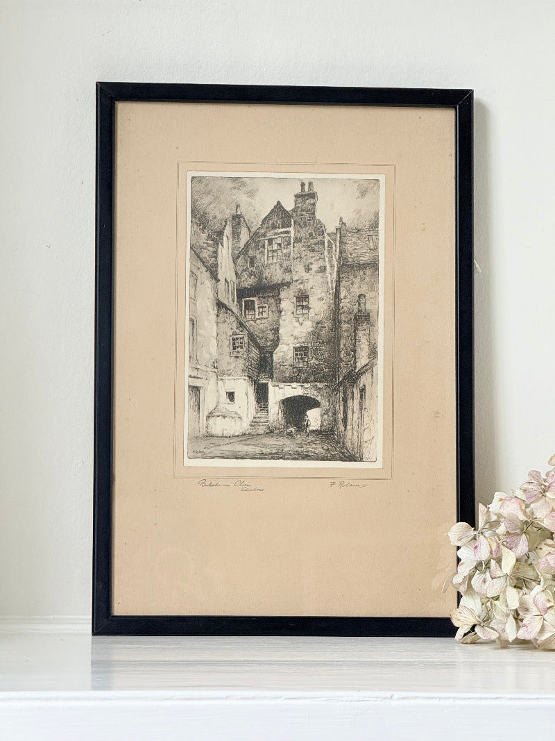 framed black and white print of edinburgh old town architecture photographed on white surface