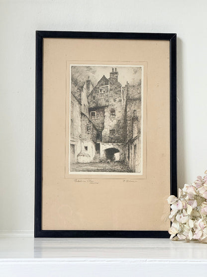 framed black and white print of edinburgh old town architecture photographed on white surface