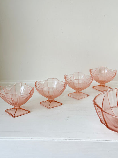 Art Deco pink pressed glass dessert service with scalloped serving bowl and four footed sundae dishes