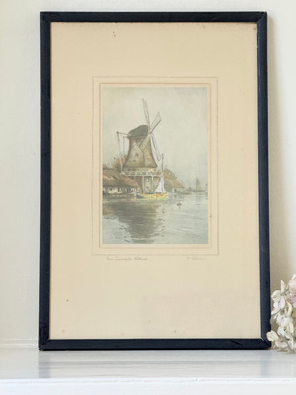 framed print of dutch windmill beside water in holland with reflection photographed on white surface