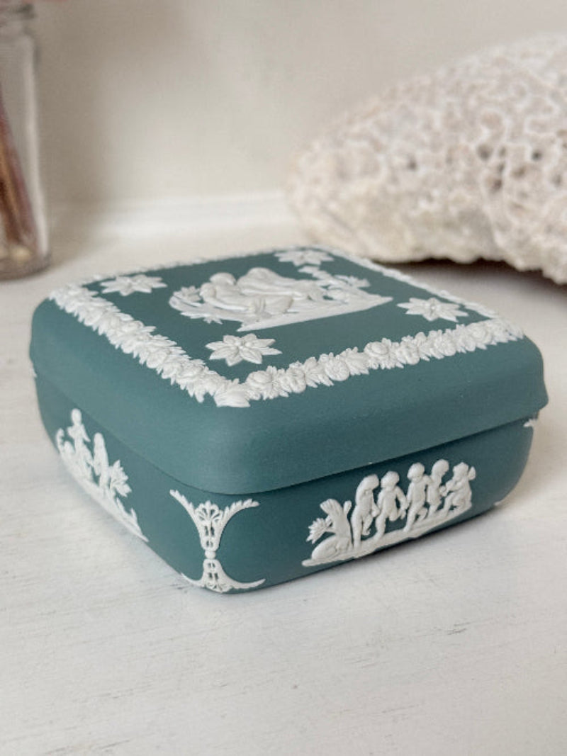 Vintage Wedgwood Jasperware teal green square lidded trinket box, decorated with white neoclassical figures and florets, styled with dried stems.