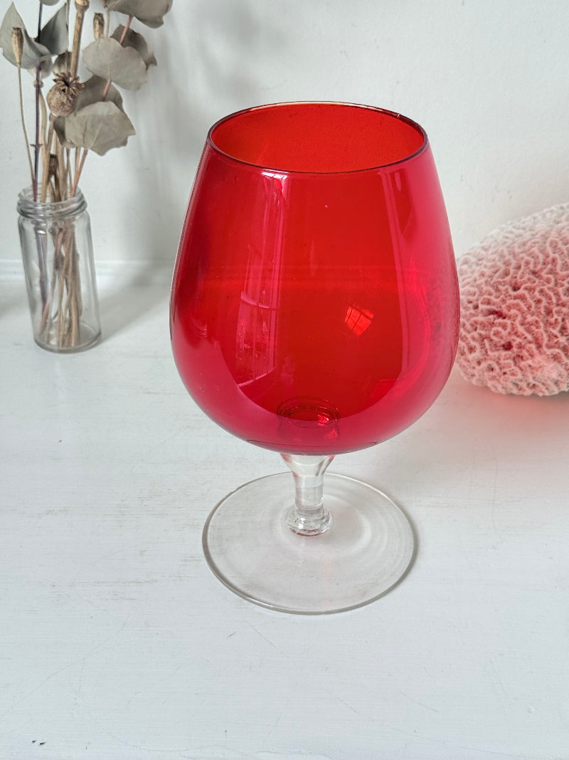 Large retro red glass brandy glass displayed on a white background.