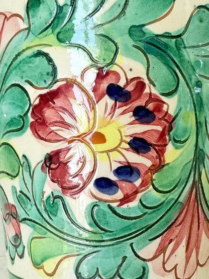 Italian handmade pot with colourful floral decoration, glazed finish, marked base, photographed on white surface.
