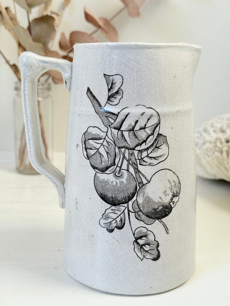 Antique English transferware jug with black fruit and leaf design, photographed on a white surface
