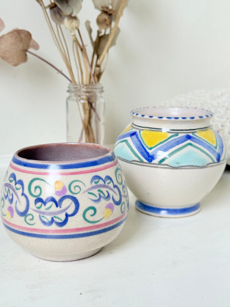 Pair of vintage studio pottery pots in blue green and pink glaze photographed on a white surface