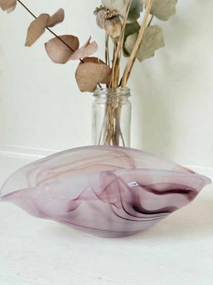 Vintage clam shaped Sowerby glass bowl in lilac purple swirl photographed on a white surface