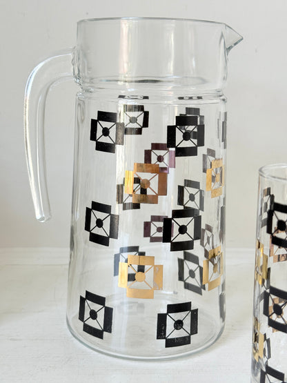 Mid century black and gold glass drinks set with jug and five highball tumblers in a geometric medallion pattern