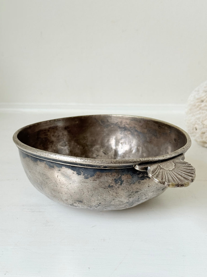 Antique Christofle silver plate bowl with decorative handle, photographed on a white surface.