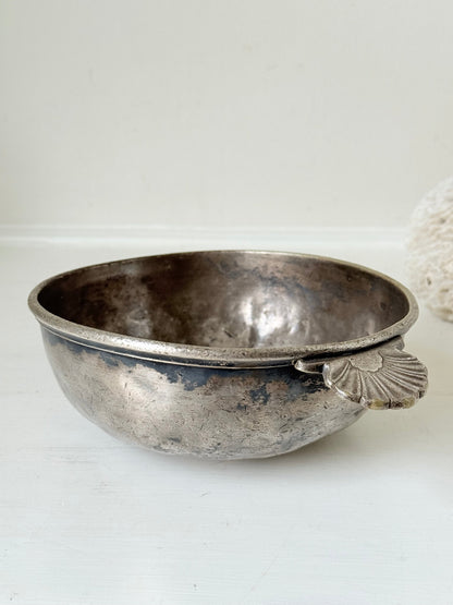 Antique Christofle silver plate bowl with decorative handle, photographed on a white surface.
