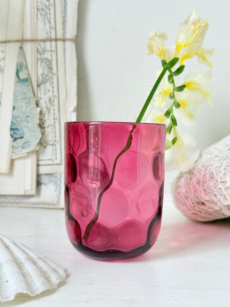 Vintage cranberry glass beaker with honeycomb optic pattern, deep pink colour and textured moulded glass for shelf styling