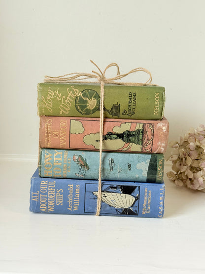 Vintage decorative book bundle in green, blue, and coral with printed lettering, tied with twine, photographed on a white surface
