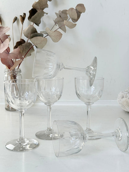 Set of 5 vintage clear glass liqueur glasses with small stems photographed on a white surface