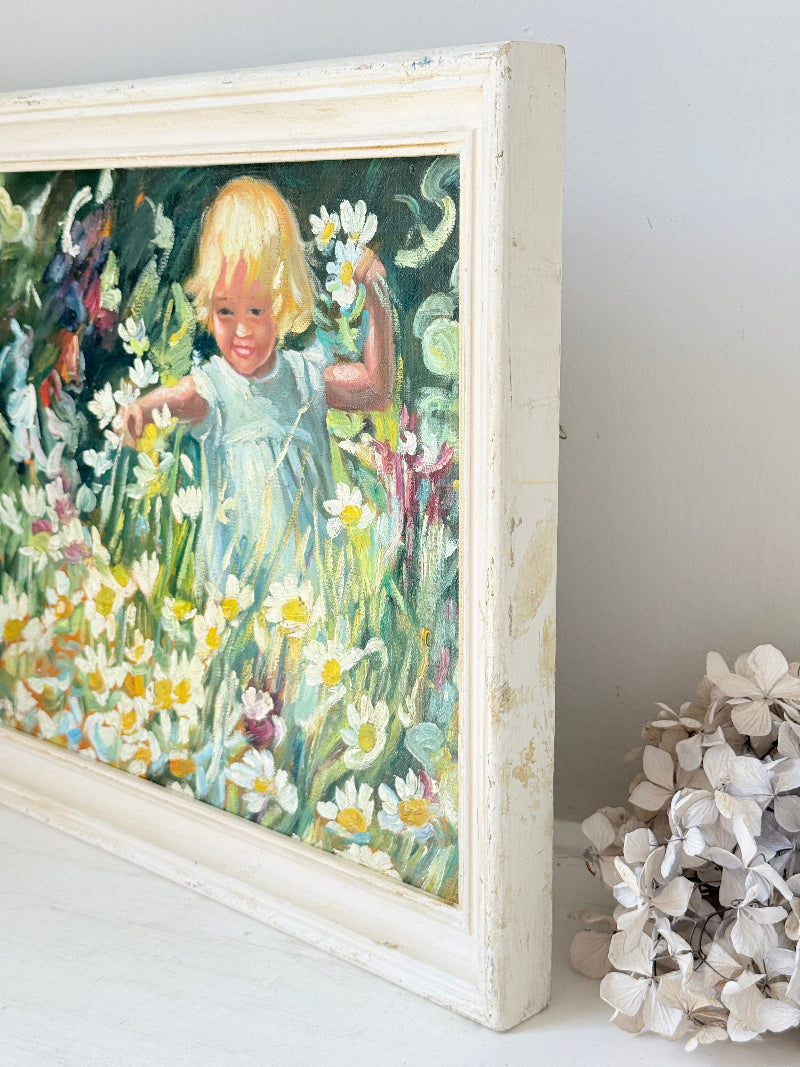 Oil painting after Dorothea Sharp of a young girl picking white flowers in a meadow, distressed white wood frame